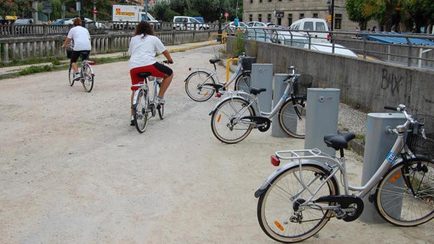 Dos usuarias adquieren las bicicletas de la base situada en el paseo de A Xunqueira de Redondela.  // FdV