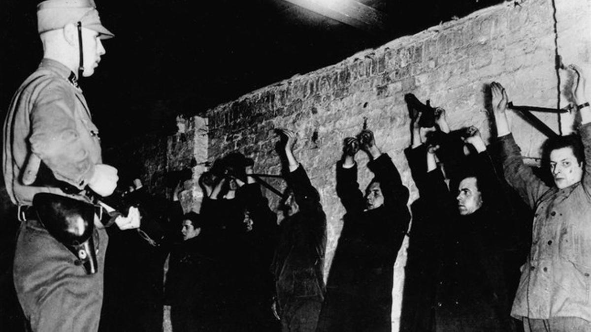 Un guardia SA amenaza a presos políticos recién llegados a los primeros campos de concentración, en 1933.