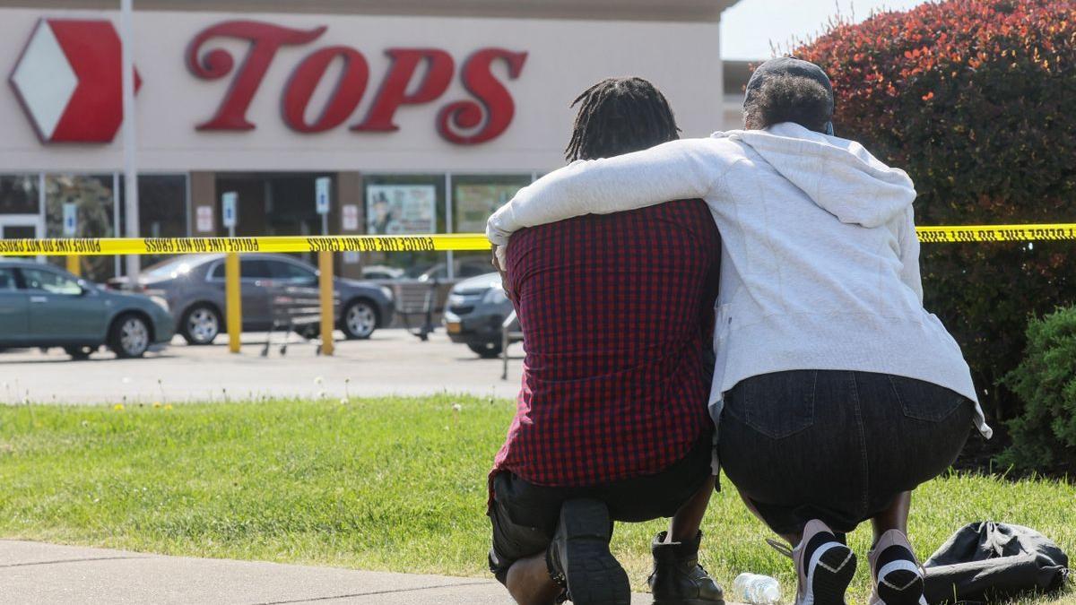 Una pareja arrodillada en las cercanías del supermercado de Búfalo donde se produjo la matanza.