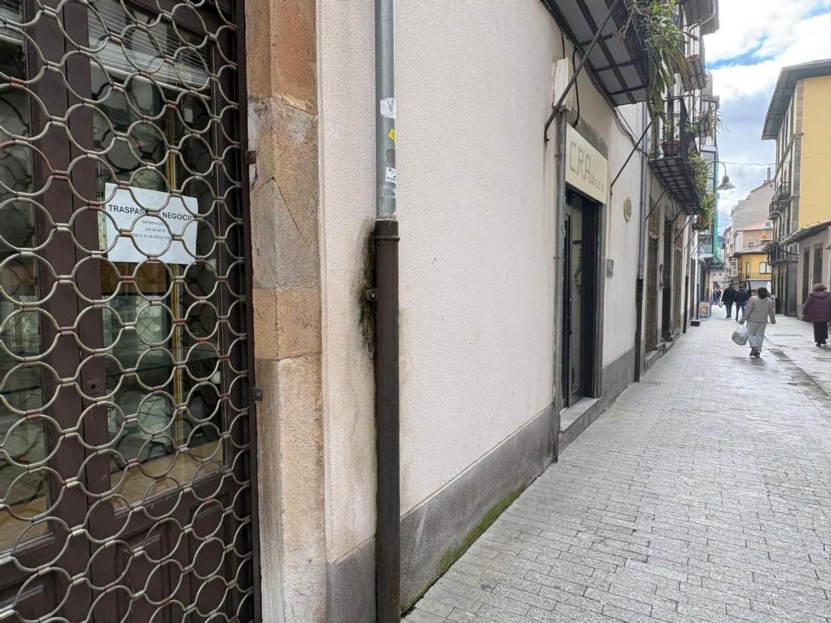 Un negocio cerrado con el cartel de traspaso en la calle Mayor de Cangas del Narcea.