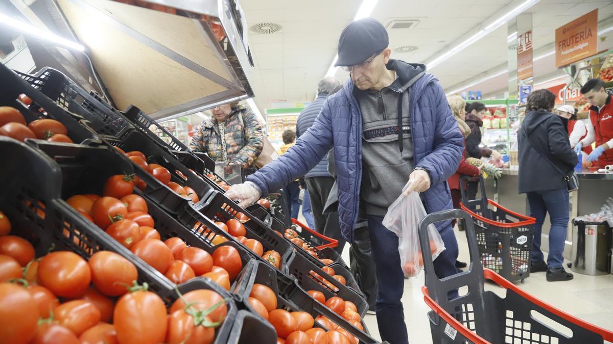 Un cliente compra verdura en un superficie de alimentación.