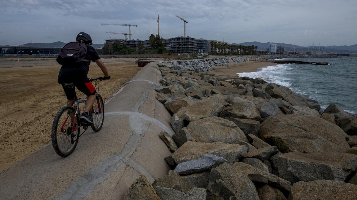 Un ciclista circula sobre el colector de Llevant, que transporta aguas residuales desde Montgat hasta Sant Adrià por la línea de costa