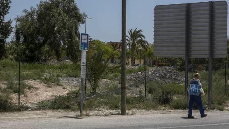 Un hombre pasa por una zona donde el vallado del campus está totalmente destrozado.