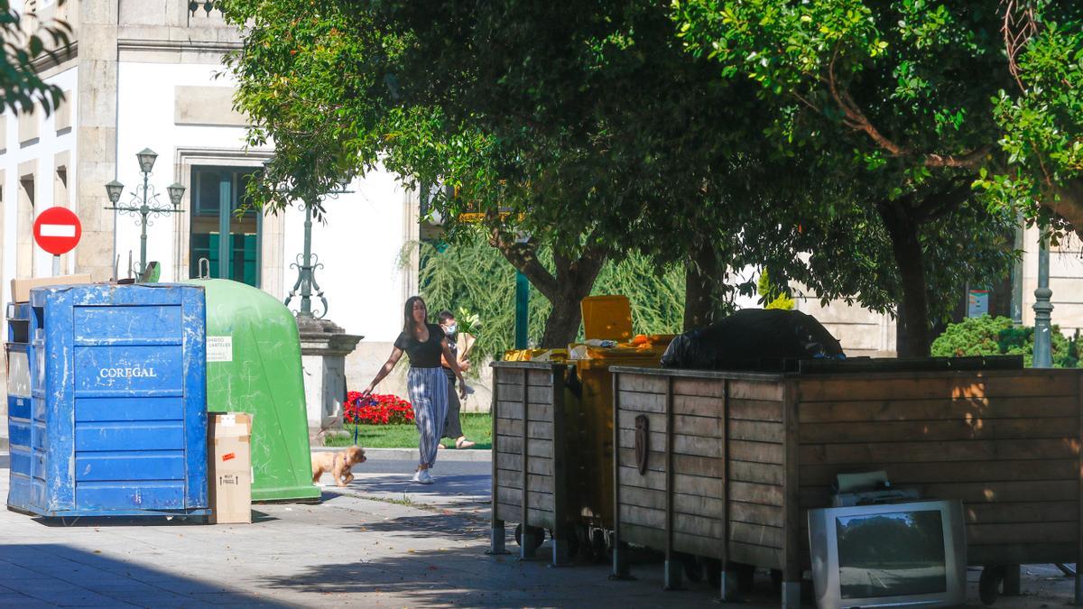 Contenedores protegidos por una jaula de madera, para mejorar su estética, en Ravella