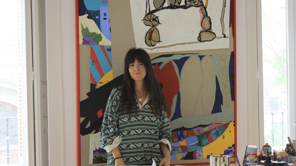 Carlota Pereiro en su estudio ante su cuadro “A los siete vendía dibujos en un hórreo”