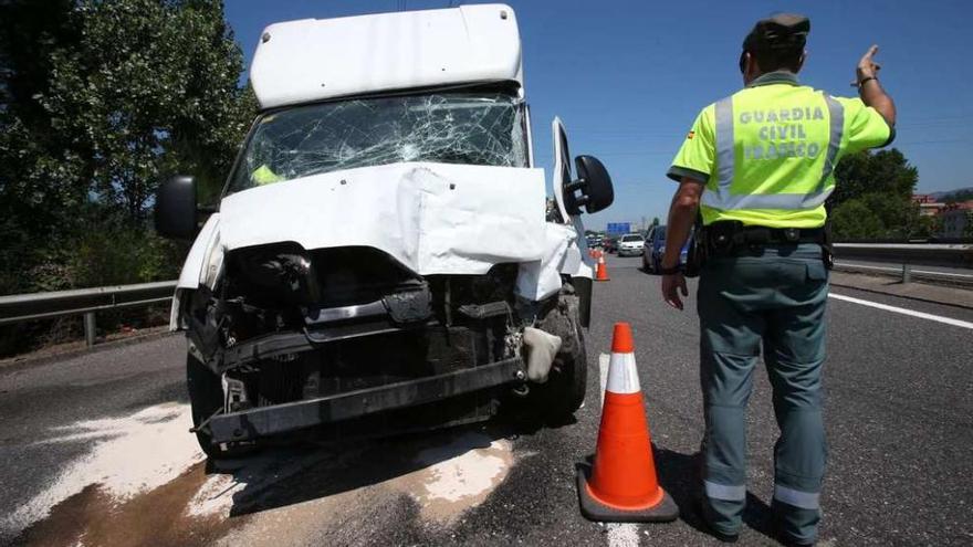 Un agente controla el tráfico en un tramo de autovía tras un accidente de una furgoneta con heridos.