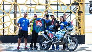 Albert Martín en el podio del Dakar, con su trofeo y la camiseta de Carles Falcón