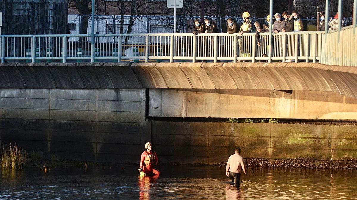 Este hombre en el agua, mientras los agentes lo vigilan desde el puente de Os Tirantes. |   // RAFA VÁZQUEZ