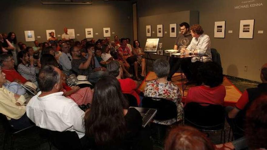 Kenna, a la derecha en la mesa, rodeado de su obra y charlando con el público en el Museo Evaristo Valle.