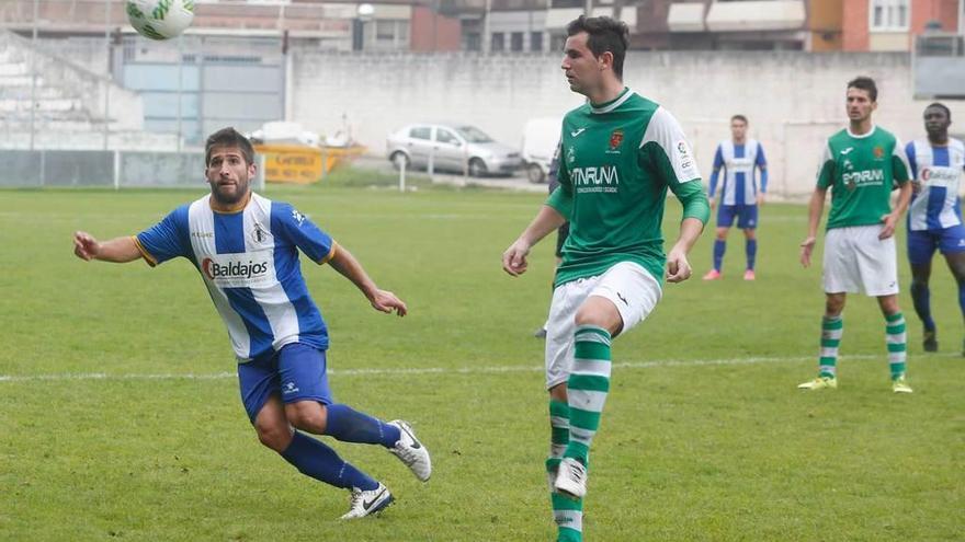 El blanquiazul Álex Arias busca el balón ante el despeje de un jugador del Llanes.