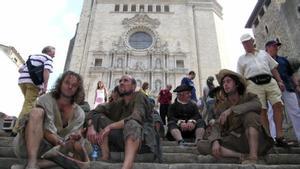 Actores secundarios y extras de una película rodada en Girona descansan en las escaleras de la catedral mientras los turistas y habitantes pasan por su lado, en noviembre de 2006.