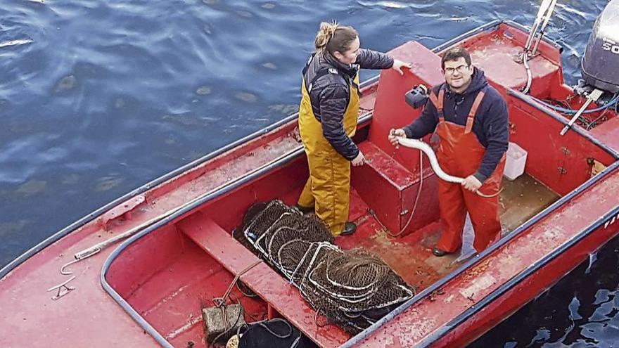 Dos de los pescadores pontecesureños de lamprea muestran uno de los ejemplares capturados, el miércoles. // FdV