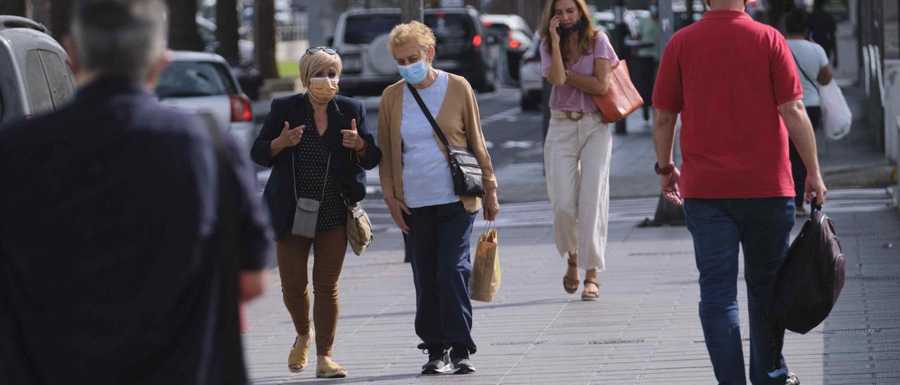 Personas con mascarilla caminan por Santa Cruz de Tenerife.