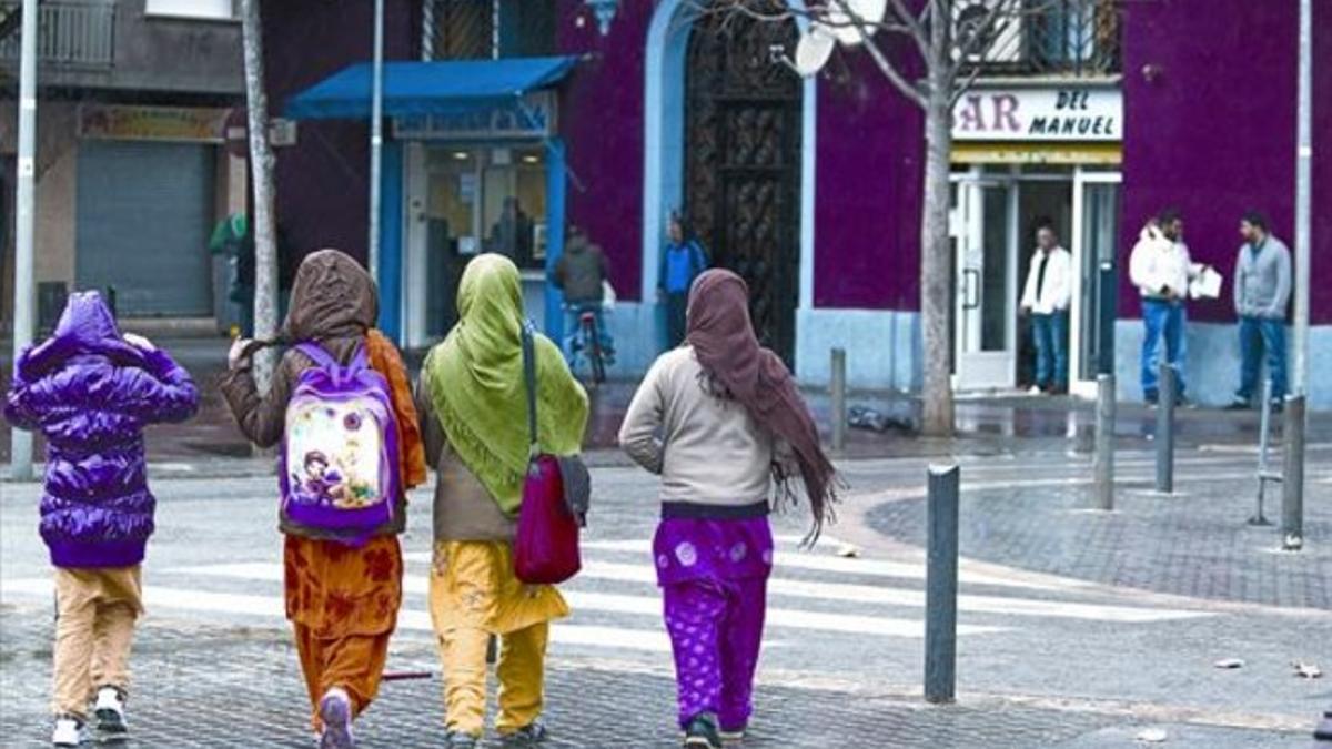 Chicas paquistanís y hombres gitanos en Sant Roc, el lunes.