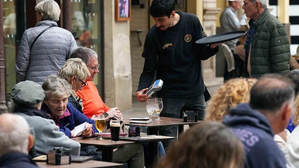 Un camarero atiende a sus clientes