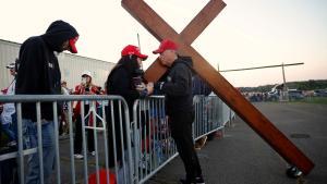 Don Deazley lleva una cruz mientras ora con Sue Hensal y otros mientras esperan en la fila para un mitin del candidato presidencial republicano, el ex presidente de los Estados Unidos, Donald Trump, en el Butler Farm Show Inc. el 5 de octubre de 2024 en Butler, Pensilvania. Trump está celebrando un mitin en Butler, en el lugar de su primer intento de asesinato.