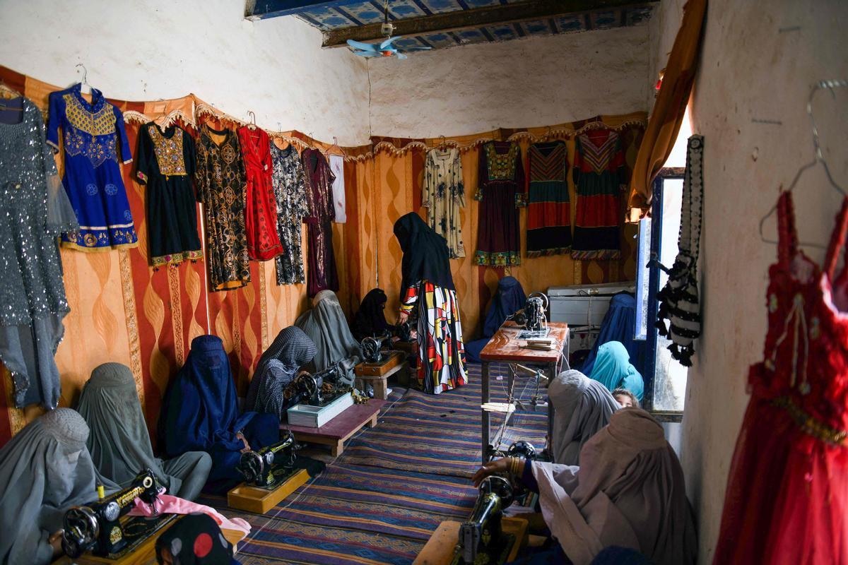 Afganas con burka trabajando en una fábrica de jabón y ropa en Kandahar