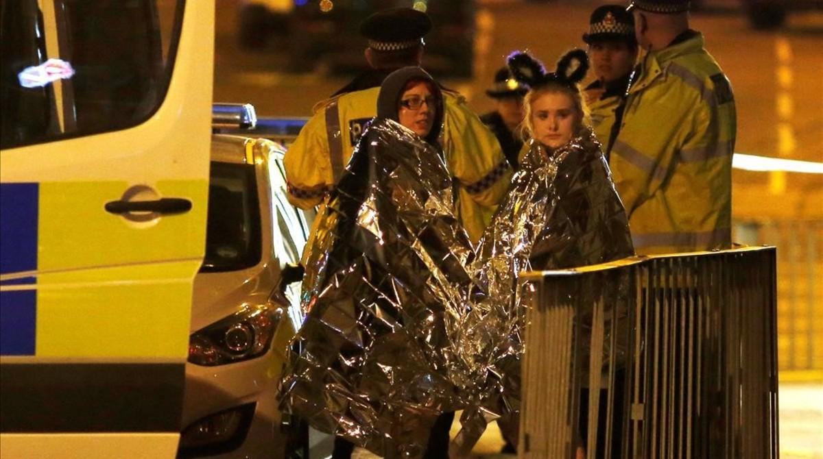Dos chicas son atendidas por los servicios de emergencia a las afueras del Manchester Arena.