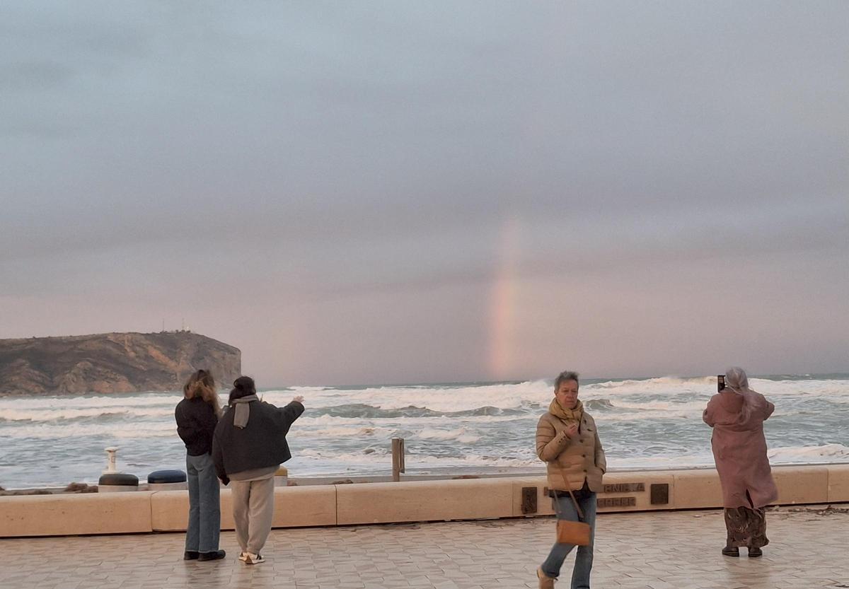 Quienes paseaban por el Arenal no se han podido resistir y han fotografiado el arcoíris con sus móviles