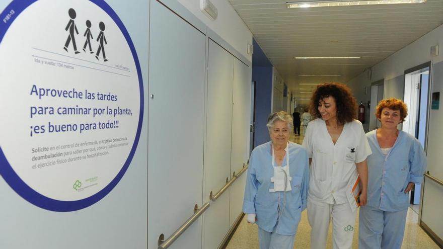 La supervisora de la Unidad de Hospitalización Cardíaca, Maite Rabadán, camina junto a dos pacientes en la séptima planta del Hospital Reina Sofía de Murcia.