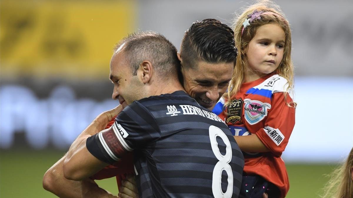 Torres se abraza a Iniesta en su último partido como profesional.