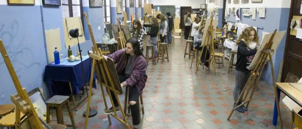 ARTES y oficios desde hace casi un siglo y medio.Alumno de uno de los ciclos de Formación Profesional de las Escuelas de Artesanos aprendiendo a cortar con una radial en los talleres de este centro educativo de Russafa. Estudiantes de Bachillerato Artístico en la Sala de Pintura de las Escuelas. f reportaje gráfico de germán caballero