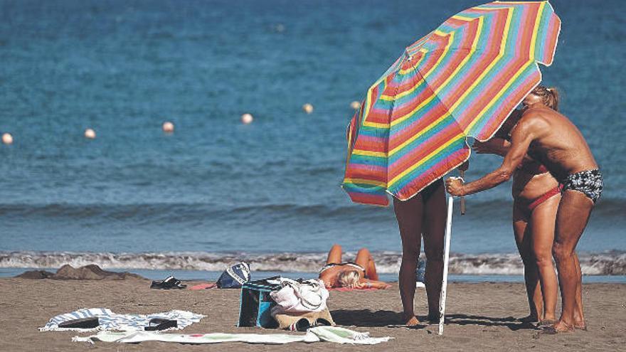 Varios bañistas disfrutan de una playa del sur de Tenerife.