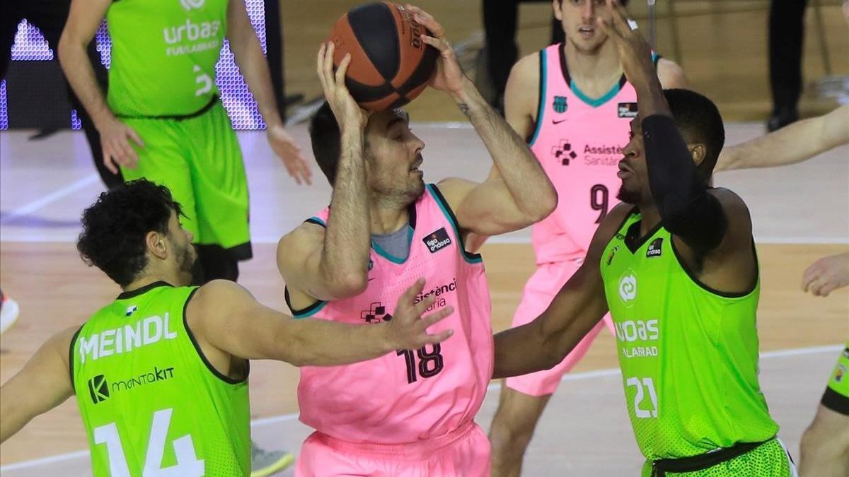 GRAF4814  FUENLABRADA  03 01 2021 - El pivot del Barca  Paul Oriola (c)  con el balon ante los jugadores del Urbas Fuenlabrada  Leonardo Meindle (i) y Shevon Thompson (d)  durante el encuentro correspondiente a la fase regular de la ACB disputado esta tarde en el Polideportivo Fernando Martin de la localidad madrilena  EFE Fernando Alvarado