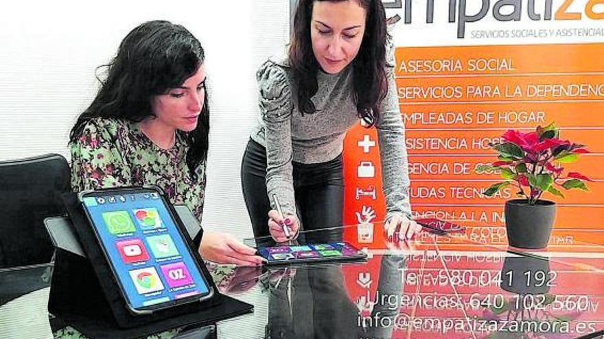 Gloria Pardo y Sandra Barba, empresarias de Empatiza, utilizan la tablet adaptada.