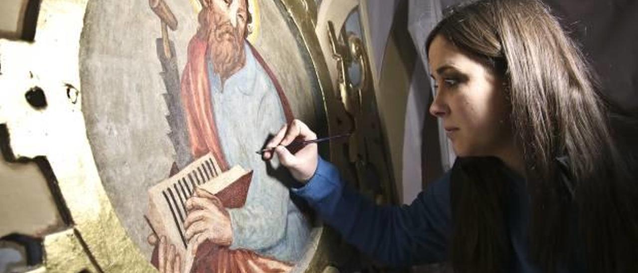 Sandra Ruiz restaurando una de las imágenes de los apóstoles que realizó el pintor en el siglo XVI.