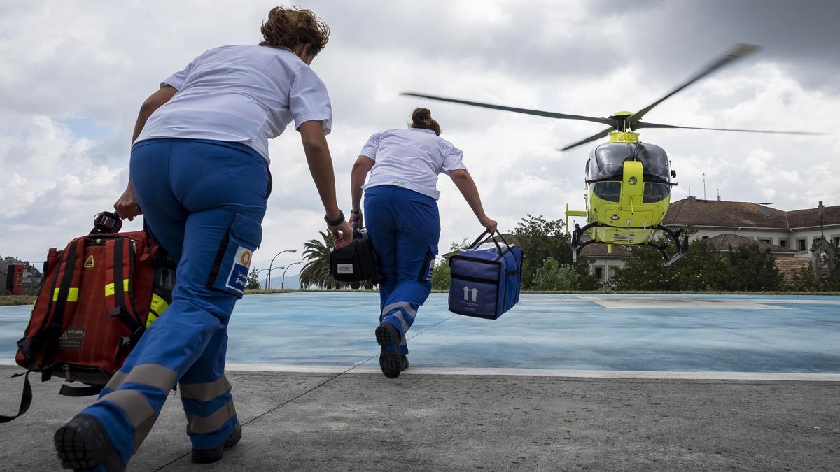 Personal de Urxencias Sanitarias antes de al helicóptero del 061 para atender una emergencia.