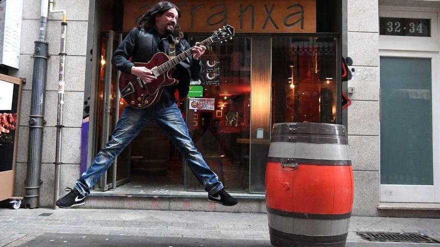 El músico Frisco toca la guitarra frente a su bar &#039;A Franxa&#039;, en la calle del mismo nombre.