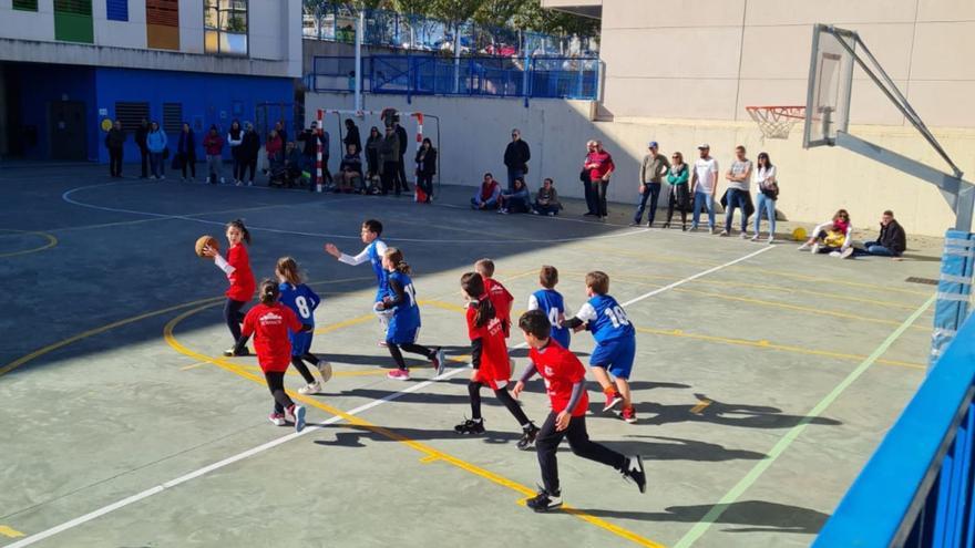 Varios alumnos juegan a baloncesto en el patio de colegio. | OCÉANO ATLÁNTICO