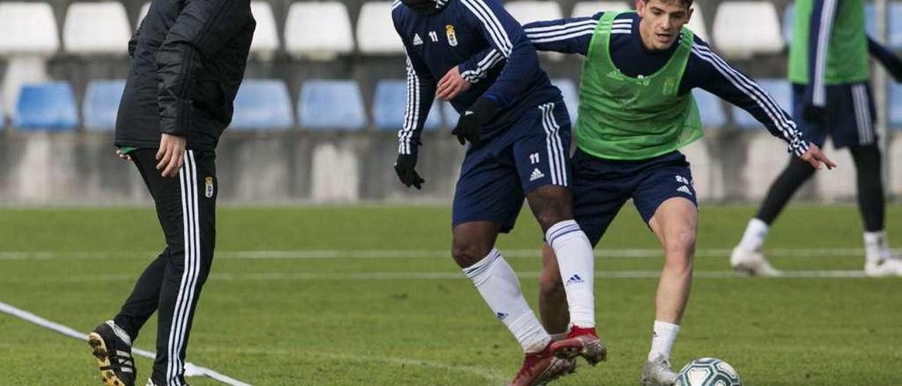 Rozada dirige el entrenamiento de ayer en El Requexón, con Bárcenas y Riki disputando un balón.