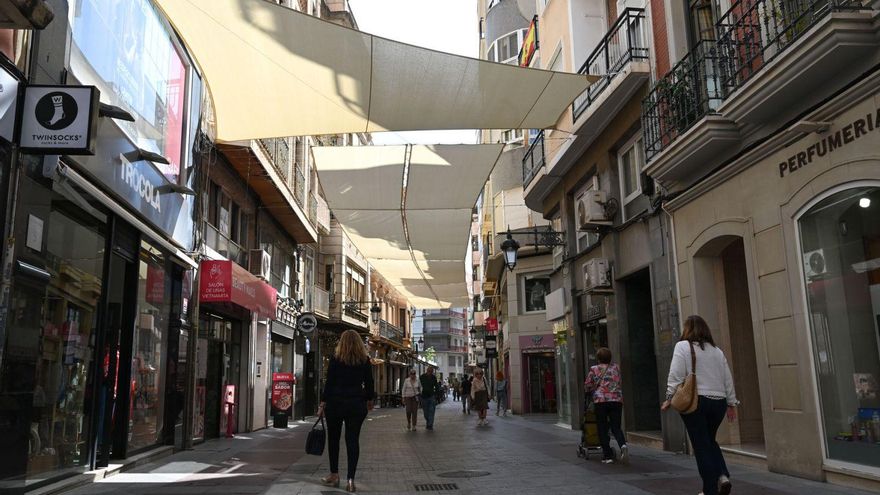 Sentado en una silla modelo imperio, sobre una plataforma única, con toldos y flores