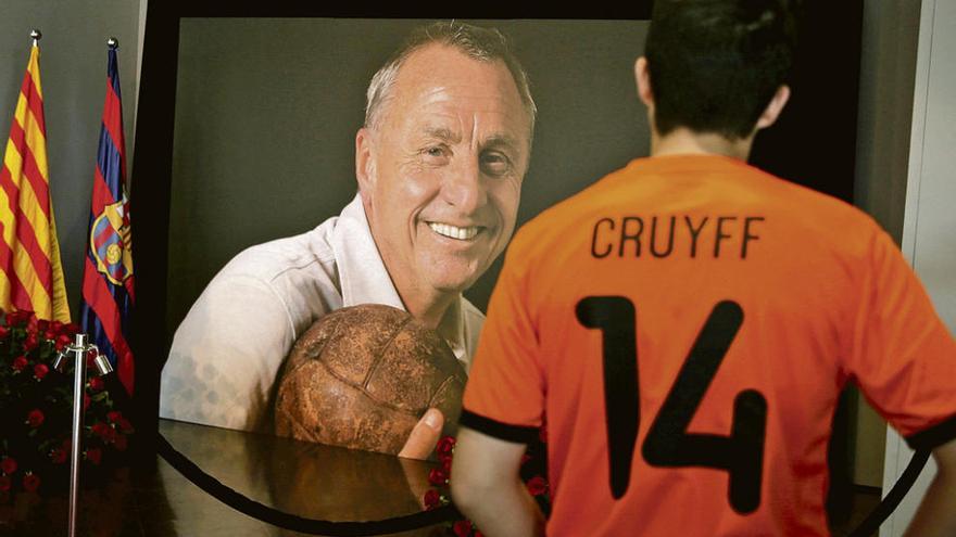 Un joven observa una fotografía de Cruyff en el memorial organizado por el Barcelona.