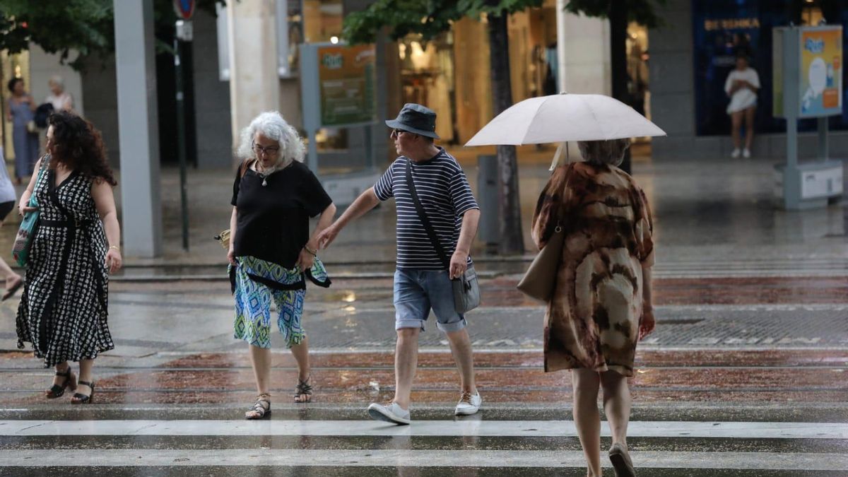 Varias personas caminan bajo la lluvia en Zaragoza en una imagen de archivo