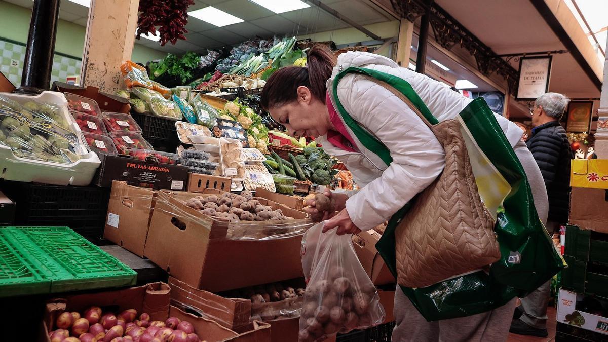 Una mujer hace la compra en un mercado de Canarias