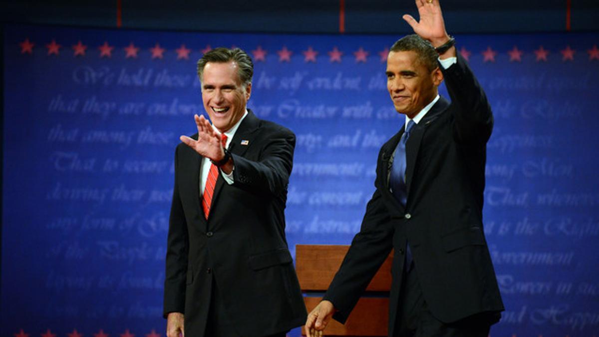 Mitt Romney y Barack Obama saludan a la audiencia a su llegada al plató del debate, el miércoles en Denver.