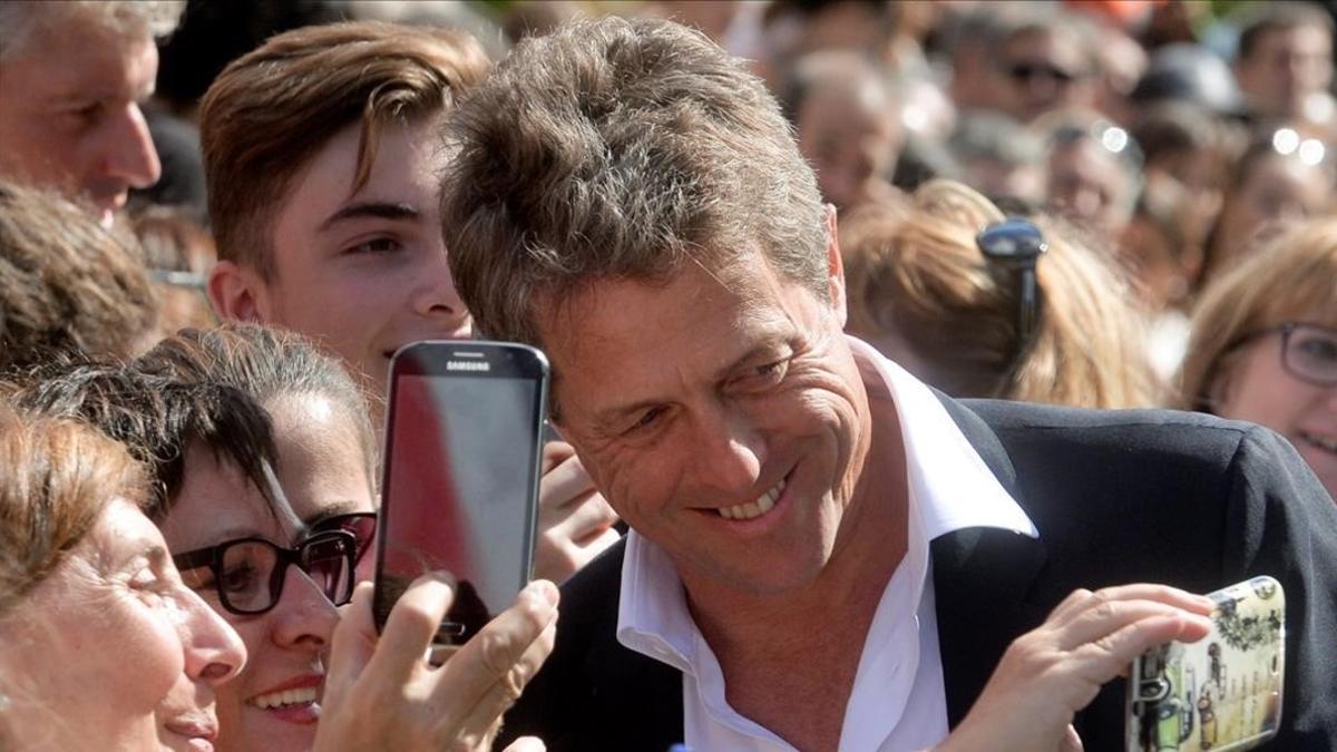 Hugh Grant, atiende a los fans, en el festival de San Sebsatián.