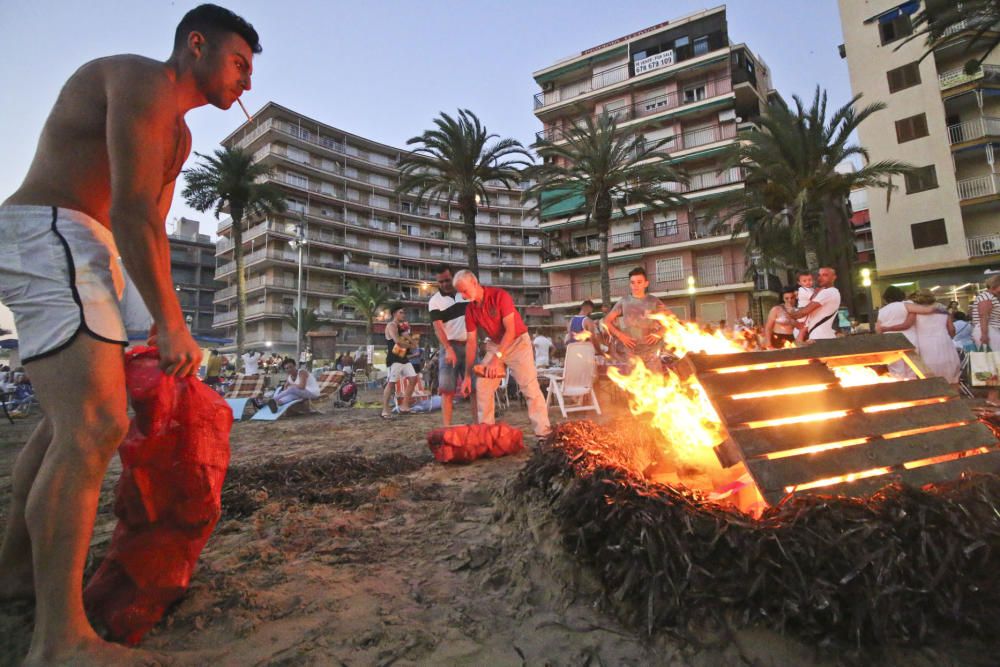 Noche de hogueras, baños, en las playas de la Vega Baja. En las imágenes grupos de amigos y familias en la playa del Cura de Torrevieja