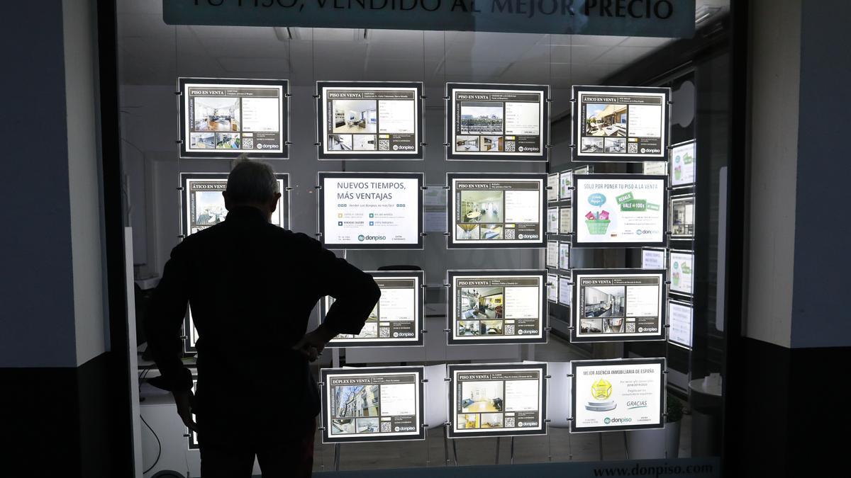 Un hombre la oferta de viviendas de una inmobiliaria de València,