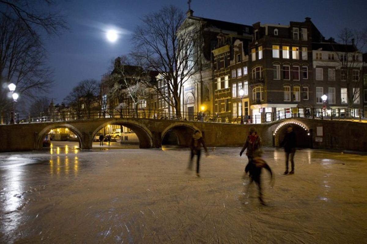 Gent patinant al canal de Prinsengracht a Amsterdam, Holanda. Els voluntaris treuen la neu del canal, que és un dels principals obstacles en la carrera de patinatge que se celebra per primera vegada en 15 anys.