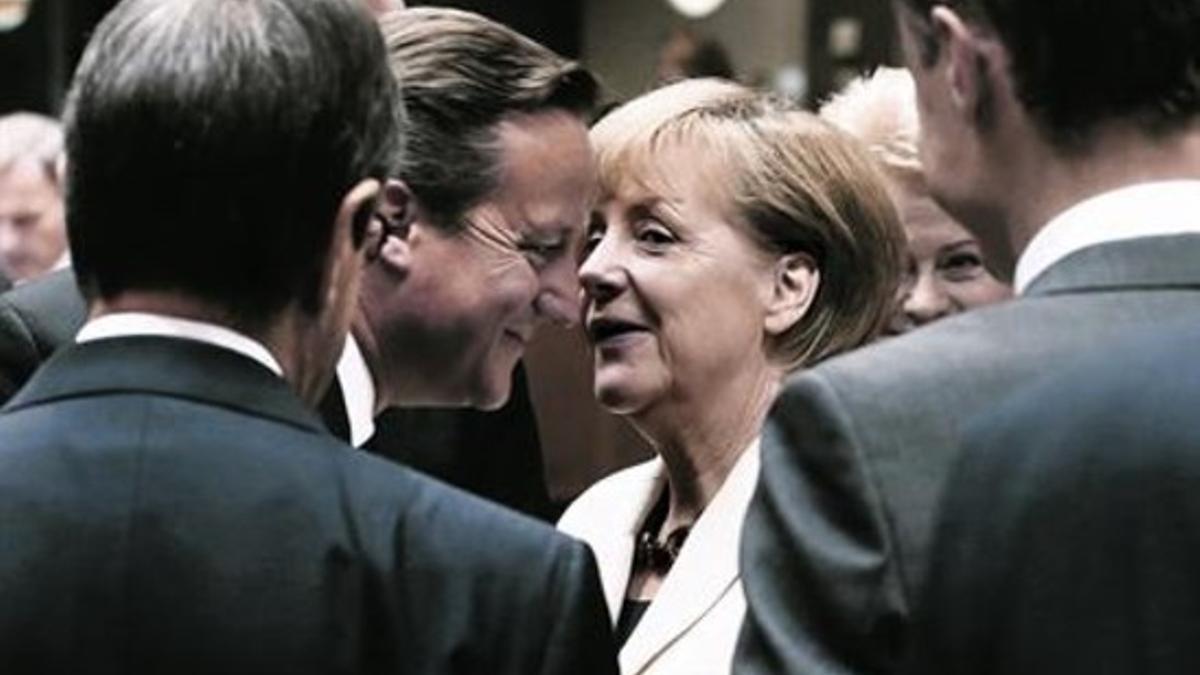 La alemana Angela Merkel, habla con el británico David Cameron, ayer.