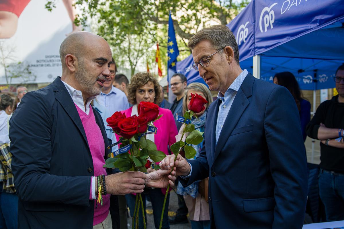 Alberto Núñez Feijóo, presidente del Partido Popular, recibe una rosa del candidato a la alcaldía de Barcelona por el PP, Daniel Sirera, en la parada del partido por Sant Jordi en la rambla de Catalunya.