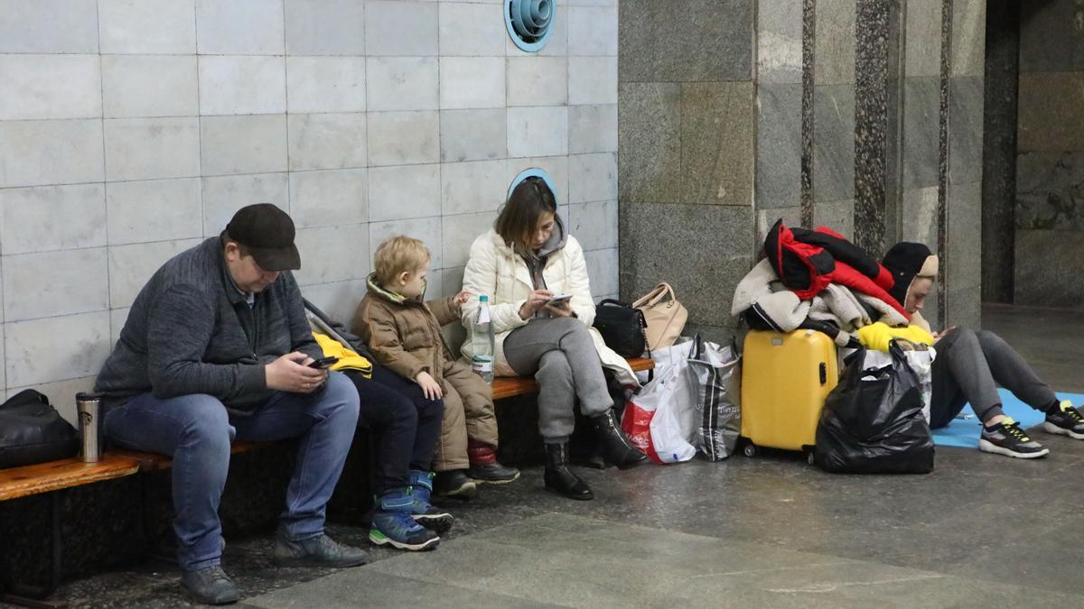 Ciudadanos ucranianos se comunican con sus teléfonos mientras se refugian de los ataques aéreos de Rusia en las estaciones de metro en Kharkiv.