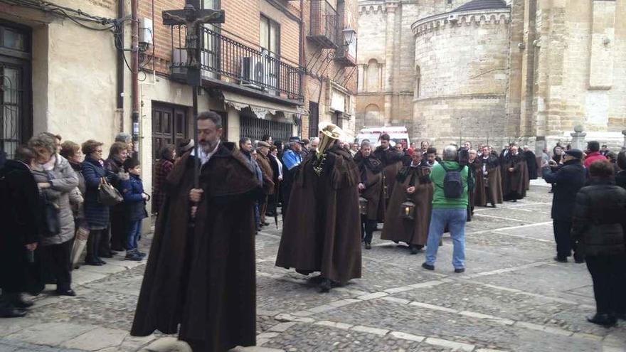 Los hermanos del Cristo del Amparo con las capas pardas acompañan el traslado de la imagen.