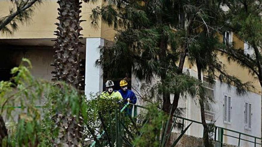 Dos bomberos salen del cuarto de contadores después de observar su estado.