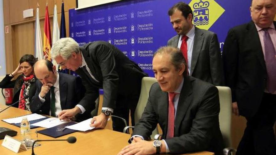 Rafael Louzán firma el crédito con los responsables del Banco de Santander. // R. Vázquez