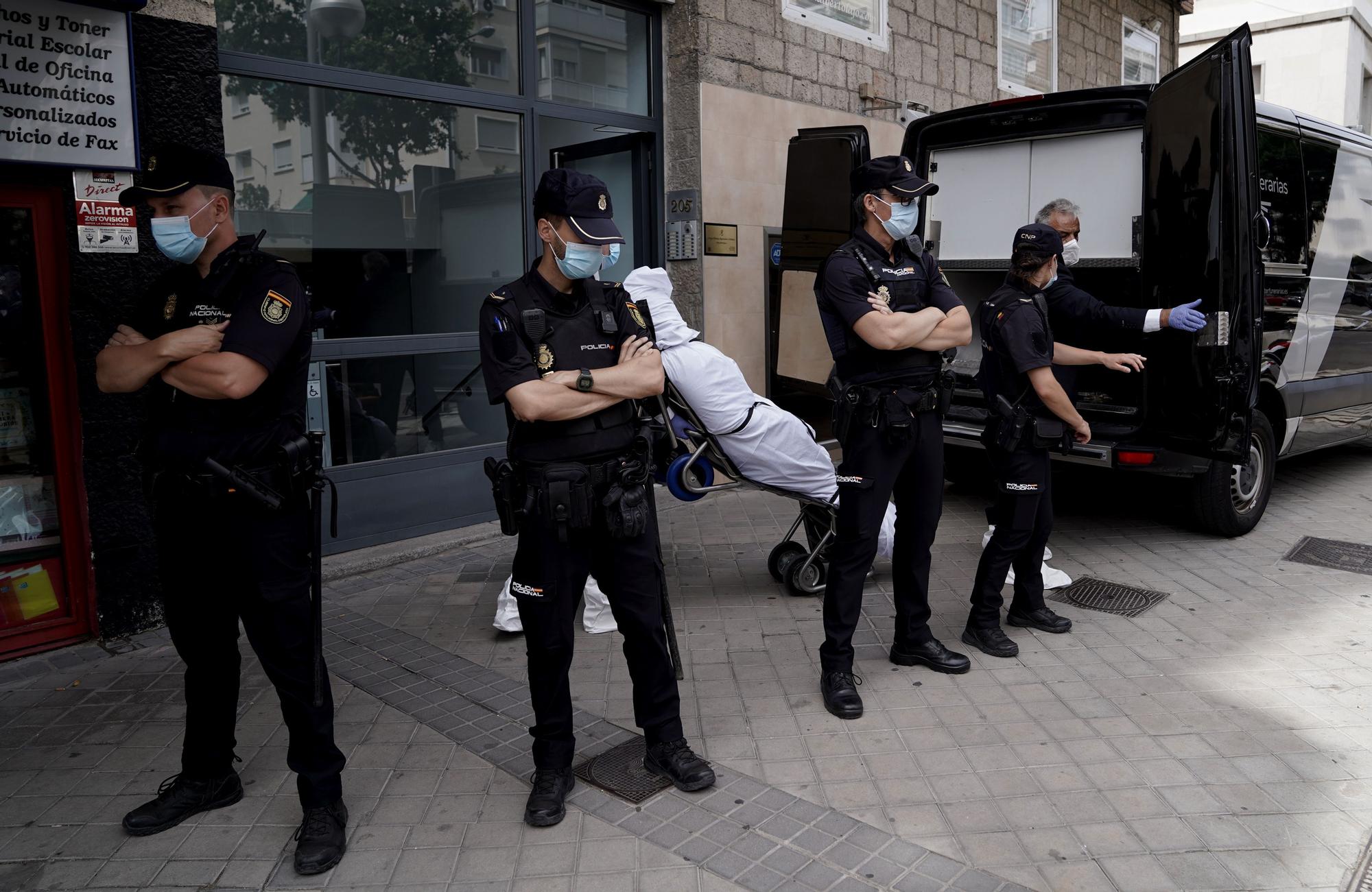 Los forenses trasladando uno de los tres cadáveres en la calle Serrano de Madrid.